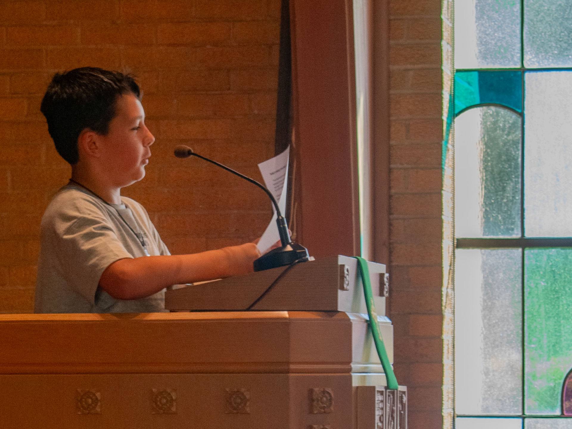 A young reader at the lectern during worship