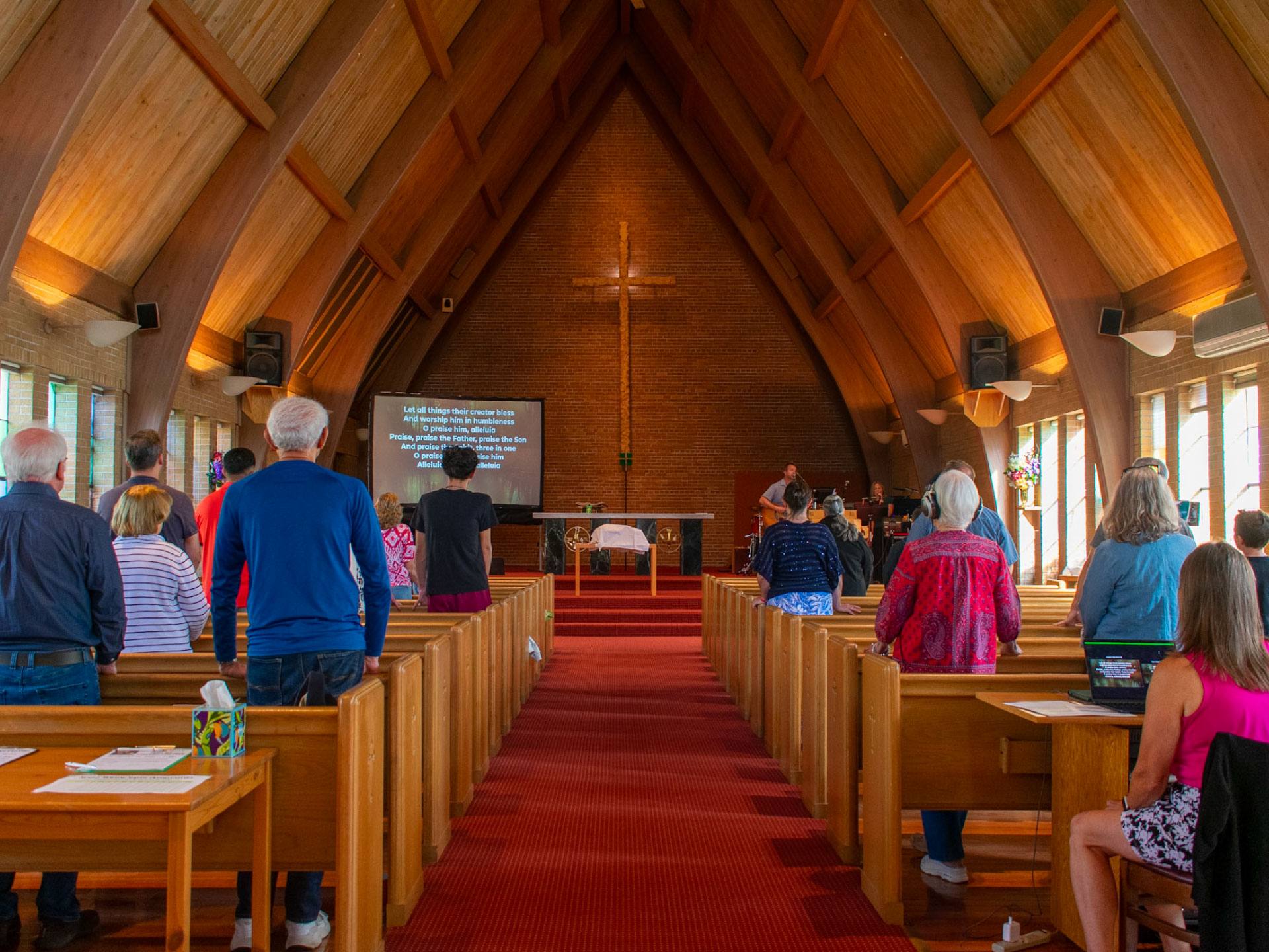 Congregation standing during Sunday worship in the sanctuary